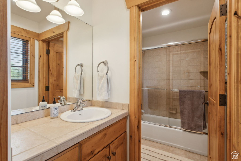 Full bathroom featuring vanity and combined bath / shower with glass door