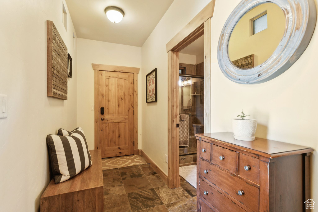 Entryway featuring baseboards and dark stone finish floors