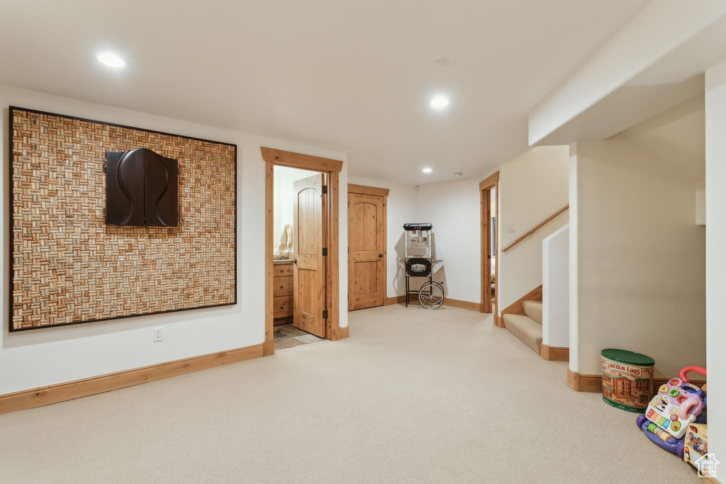 Finished below grade area featuring carpet flooring, recessed lighting, baseboards, and stairs