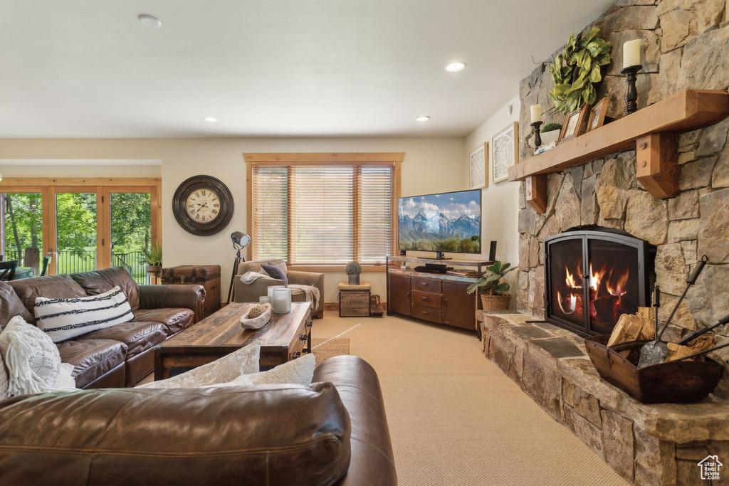 Living area featuring light carpet, a stone fireplace, and recessed lighting