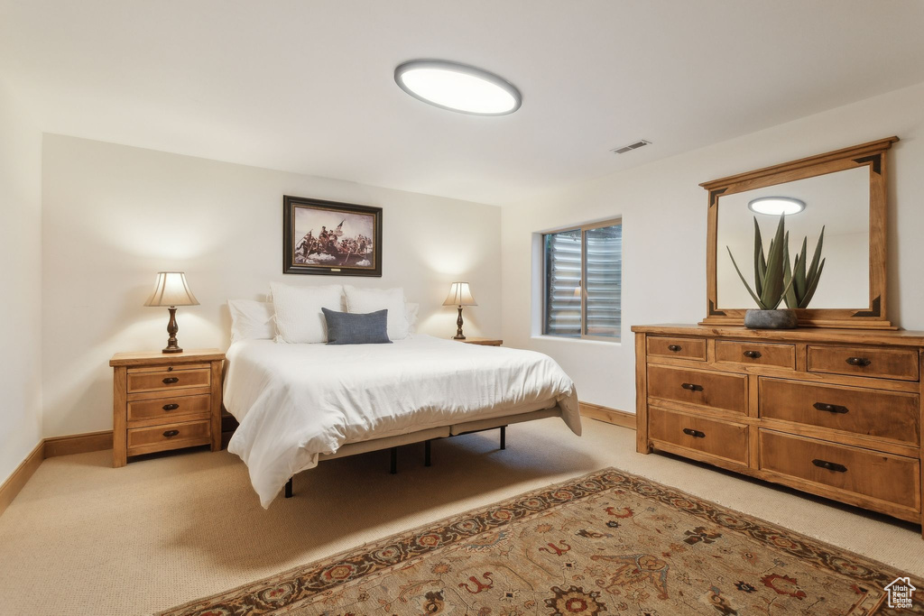 Bedroom with light colored carpet and baseboards