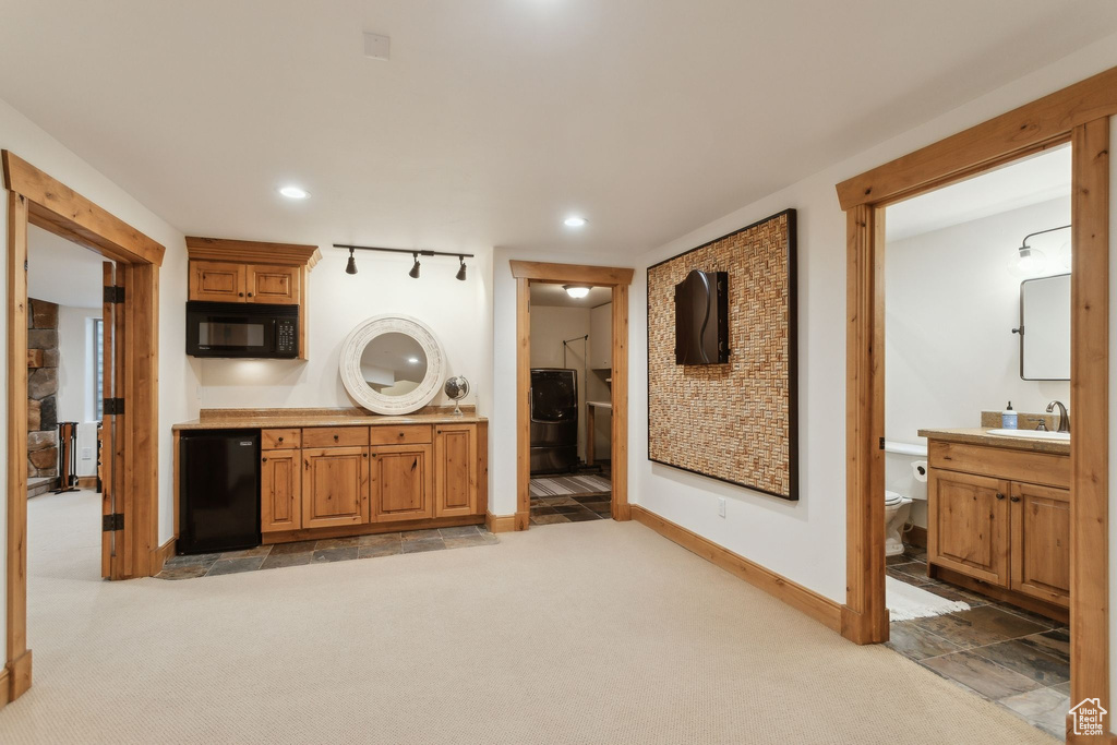 Laundry area with light carpet, baseboards, and recessed lighting