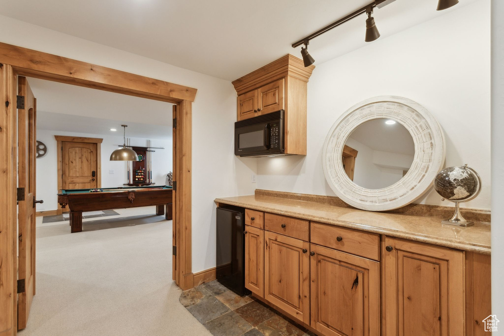 Kitchen with black microwave, track lighting, billiards table, refrigerator, and light countertops