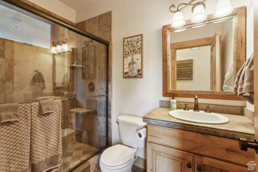 Bathroom featuring vanity, toilet, and a shower stall