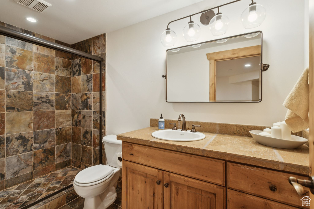 Full bath featuring vanity, toilet, and a stall shower