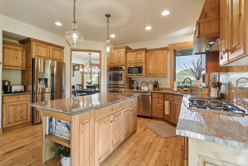 Kitchen featuring appliances with stainless steel finishes, a sink, light wood-style floors, light stone counters, and recessed lighting