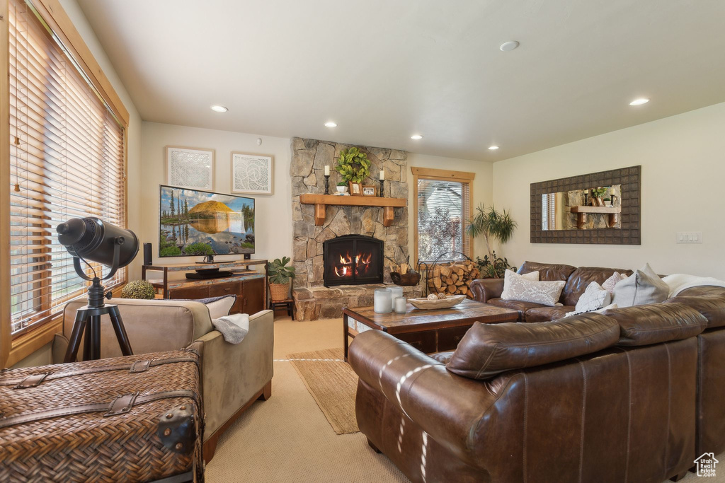 Living area with light colored carpet, a fireplace, plenty of natural light, and recessed lighting