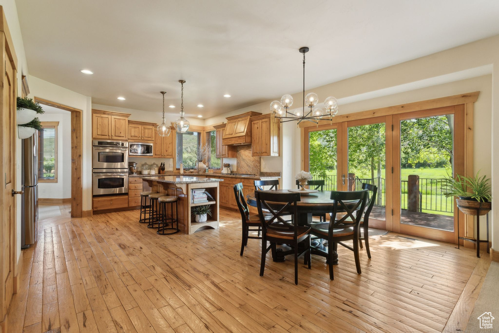 Dining space with a chandelier, recessed lighting, and light wood-style flooring