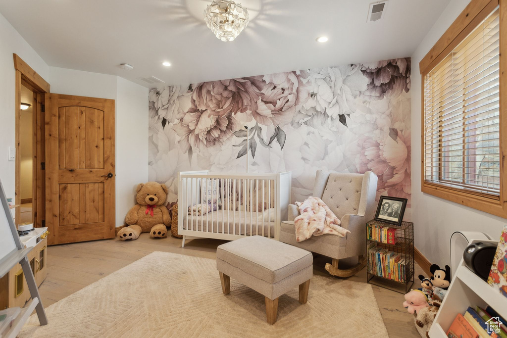 Bedroom with recessed lighting, wood finished floors, and an accent wall