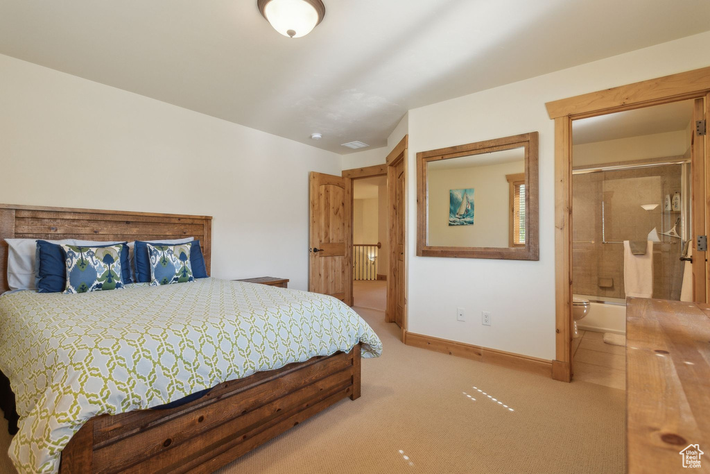 Carpeted bedroom featuring baseboards, connected bathroom, and radiator heating unit