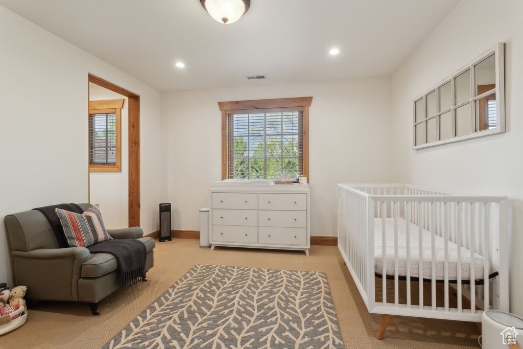 Bedroom with light colored carpet, recessed lighting, a nursery area, and baseboards