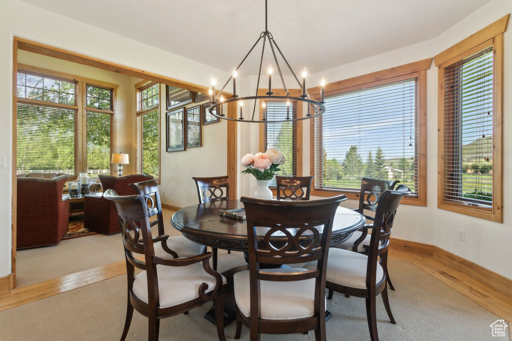 Dining room featuring a chandelier, light wood-style floors, and baseboards