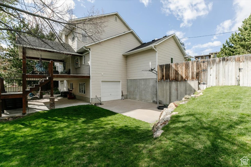 Rear view of house with stairway, a patio area, a lawn, and fence