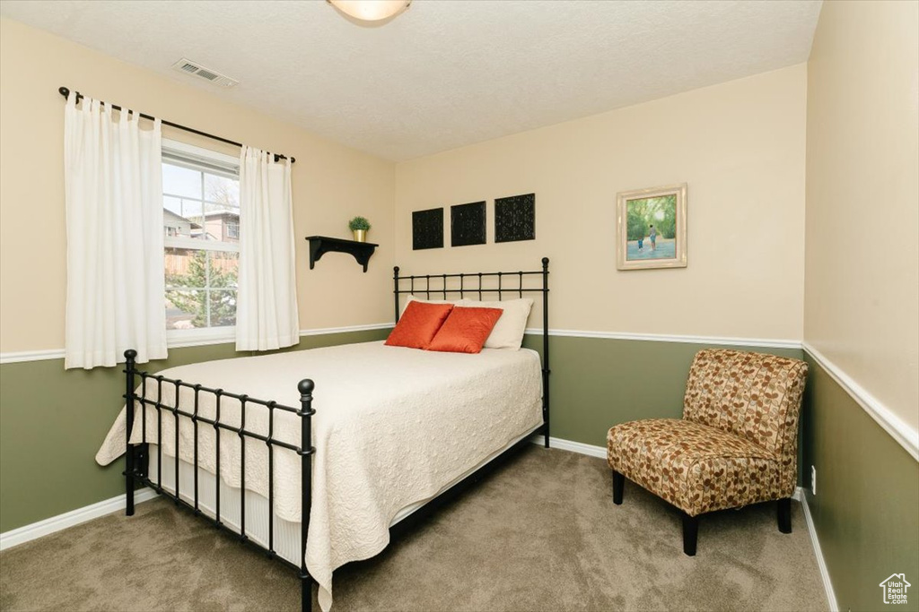 Carpeted bedroom with baseboards and visible vents
