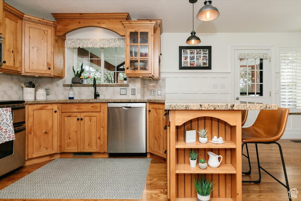 Kitchen with dishwasher, a wealth of natural light, tasteful backsplash, and stove