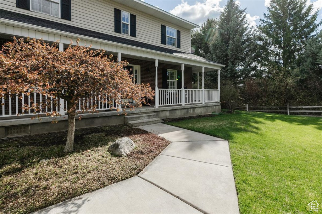 Entrance to property with a yard and a porch