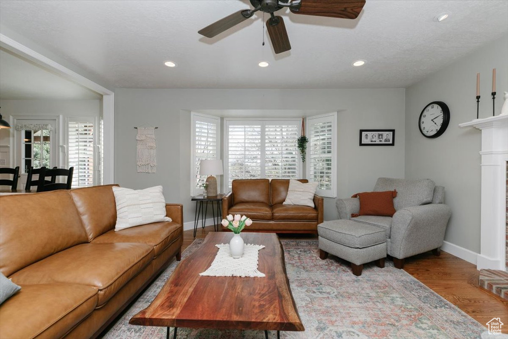 Living room featuring ceiling fan, baseboards, wood finished floors, and recessed lighting
