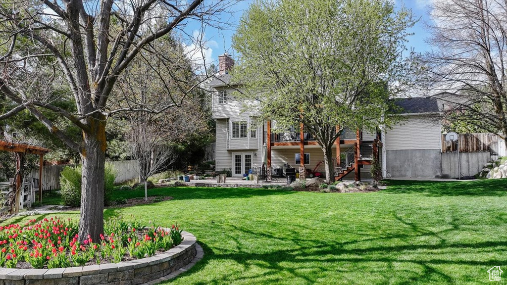 Back of house featuring french doors, fence, a patio area, a lawn, and stairway