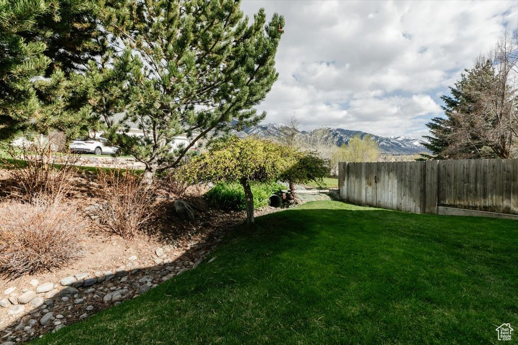 View of yard with fence and a mountain view