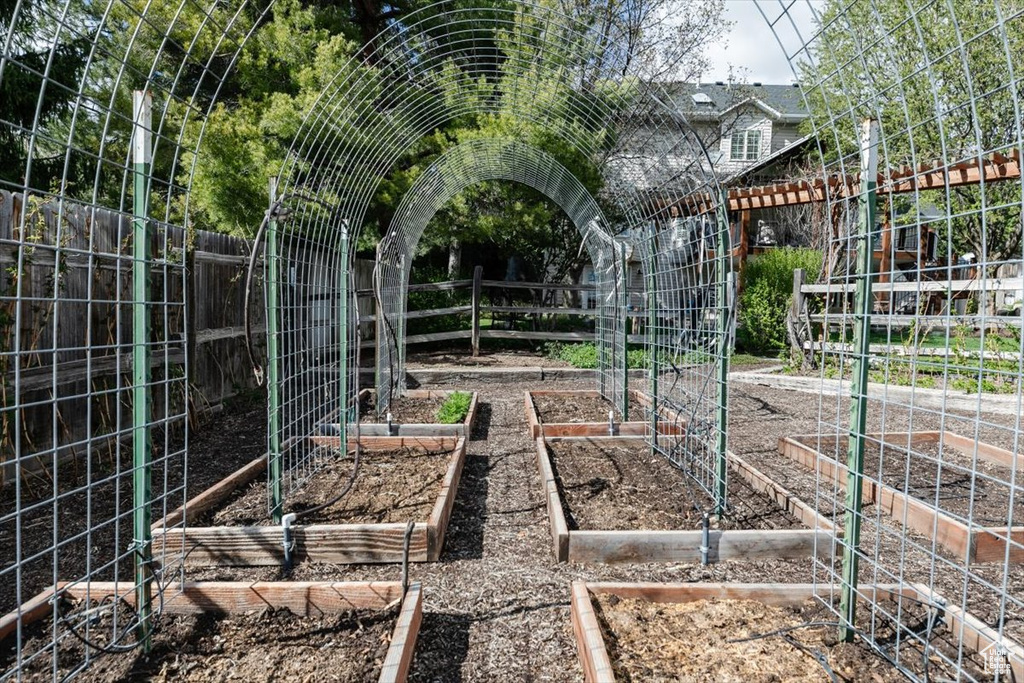 View of yard featuring fence and a vegetable garden
