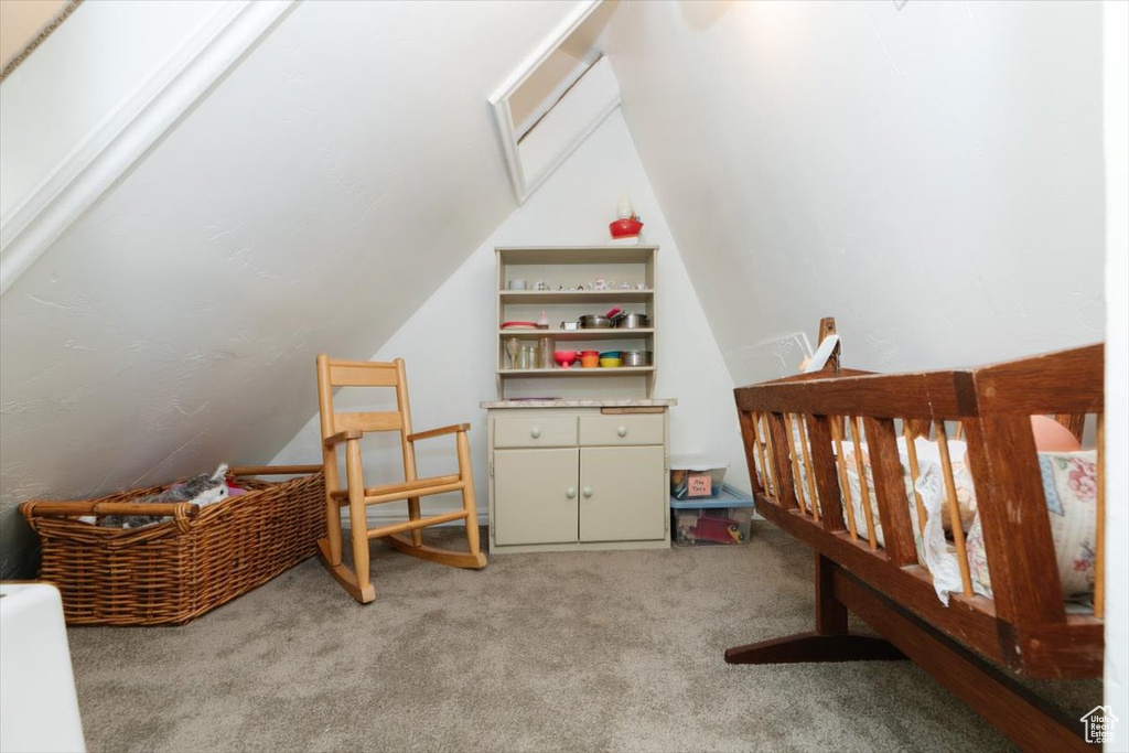 Bedroom featuring lofted ceiling and carpet flooring