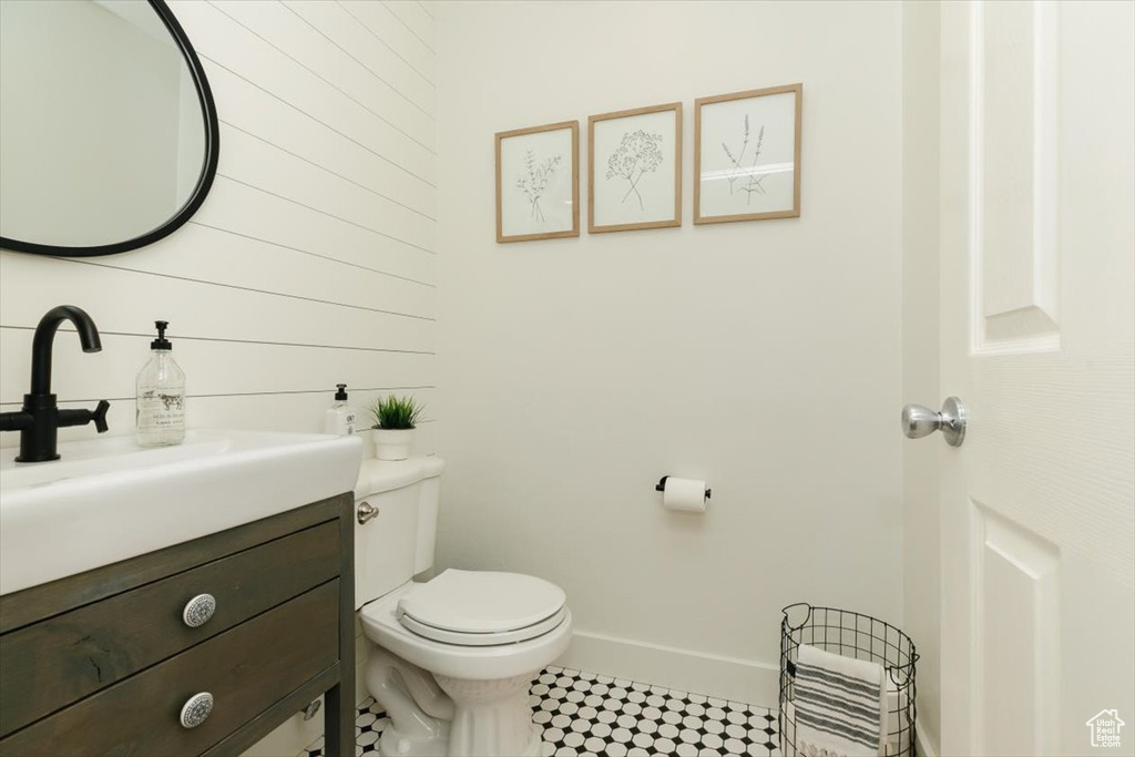 Bathroom featuring toilet, vanity, and baseboards