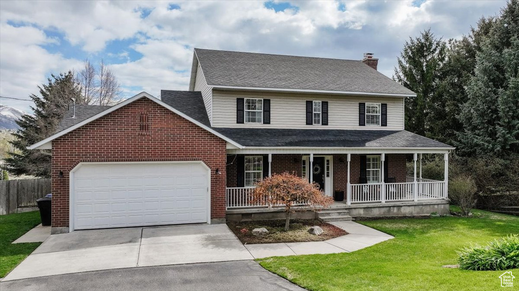 View of front of home featuring roof with shingles, covered porch, concrete driveway, a garage, and brick siding
