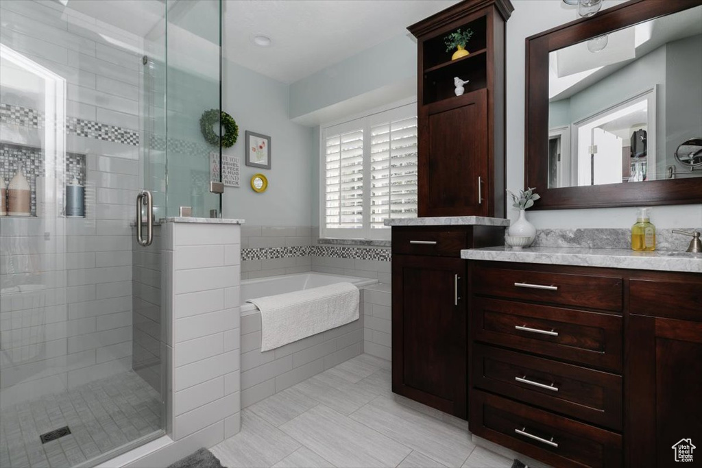 Bathroom with a garden tub, vanity, tile patterned flooring, and a stall shower