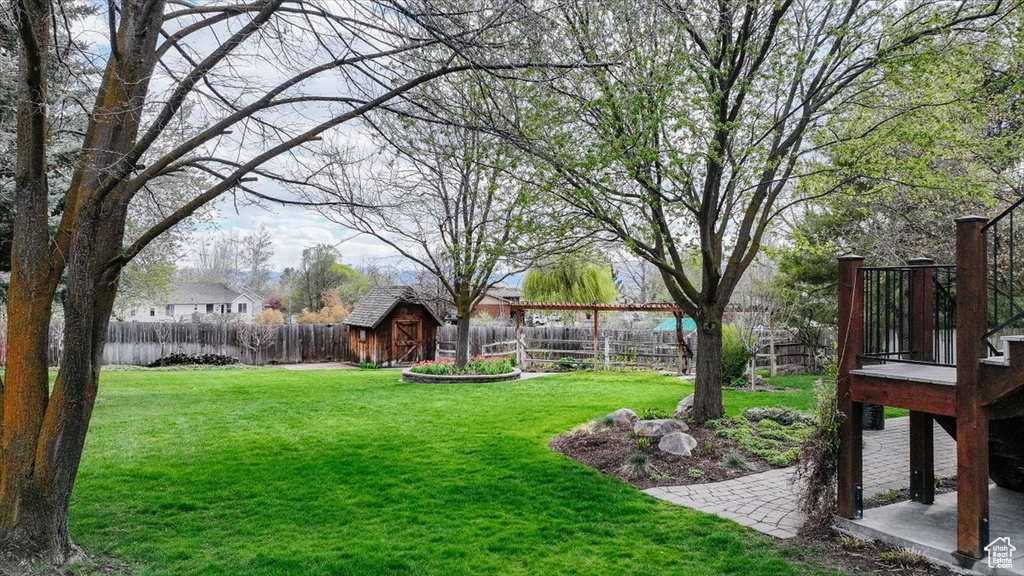 View of yard with a fenced backyard, a storage unit, and an outdoor structure