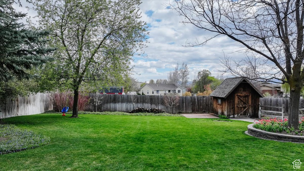 View of yard featuring an outbuilding, a shed, and a fenced backyard