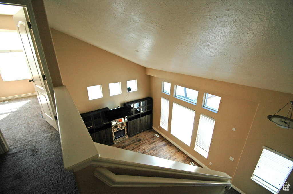 Stairway with a textured ceiling, vaulted ceiling, and baseboards