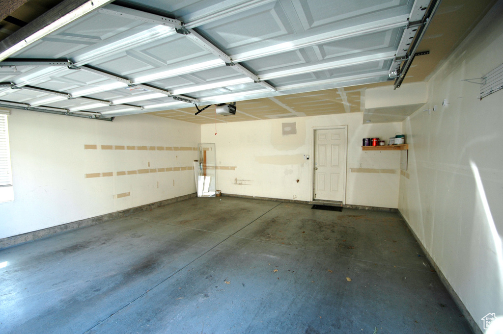 Garage featuring baseboards and a garage door opener