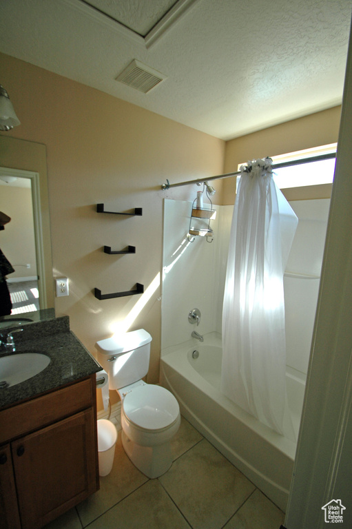 Bathroom featuring vanity, shower / bath combo with shower curtain, tile patterned floors, toilet, and visible vents