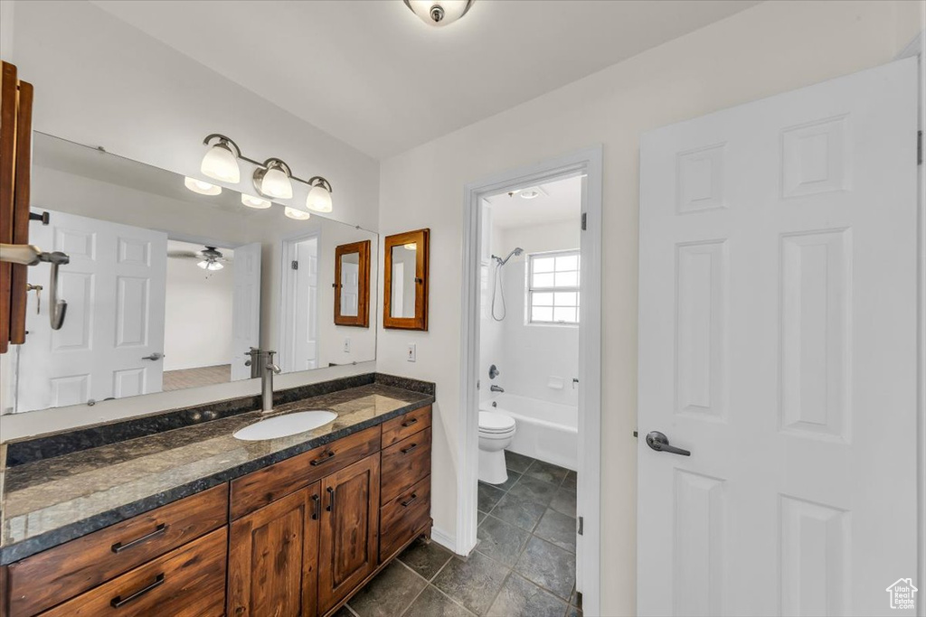 Full bath featuring ceiling fan, toilet, vanity, and shower / bath combination