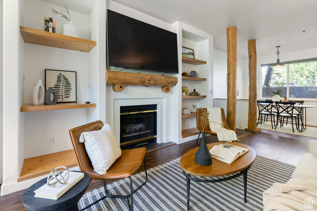 Living room featuring wood finished floors, a fireplace with raised hearth, and baseboards