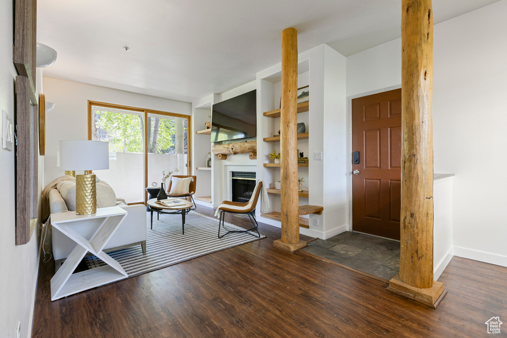 Foyer entrance featuring wood finished floors, baseboards, and a fireplace