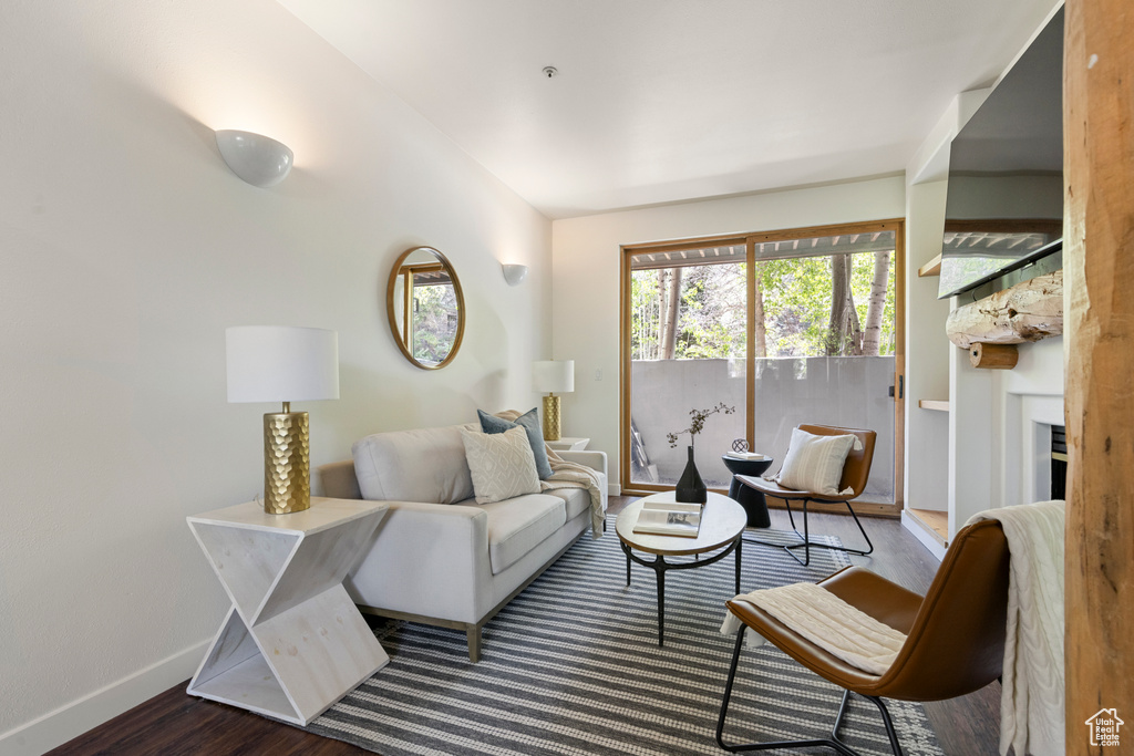 Living area featuring wood finished floors, baseboards, and a large fireplace