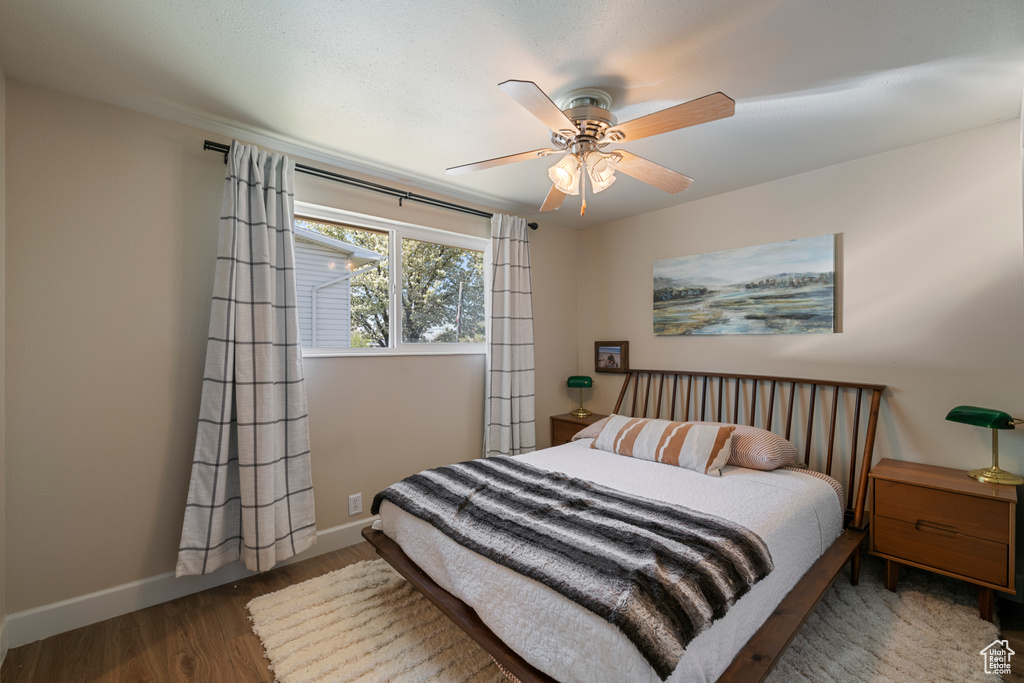 Bedroom with ceiling fan, baseboards, and wood finished floors