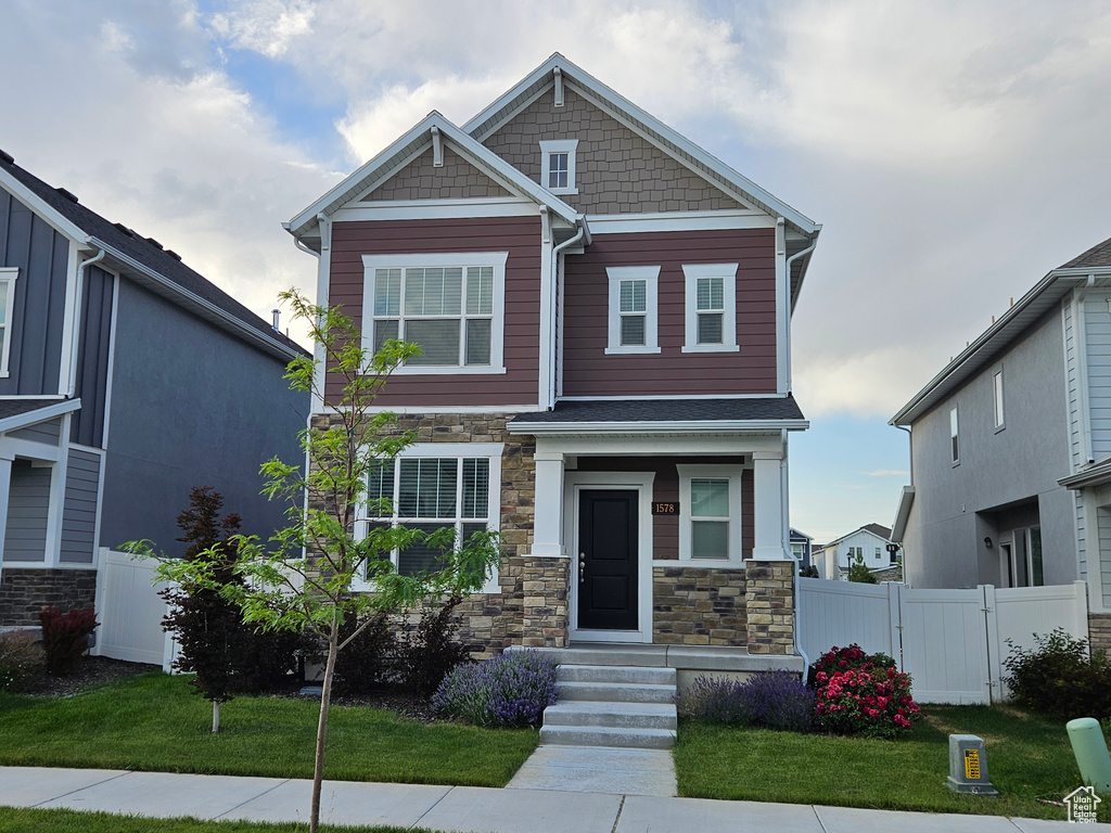 Craftsman inspired home featuring stone siding