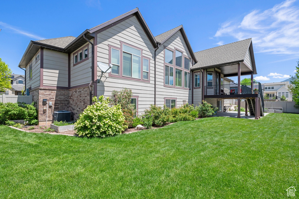 Back of house featuring stairway, a deck, and central AC