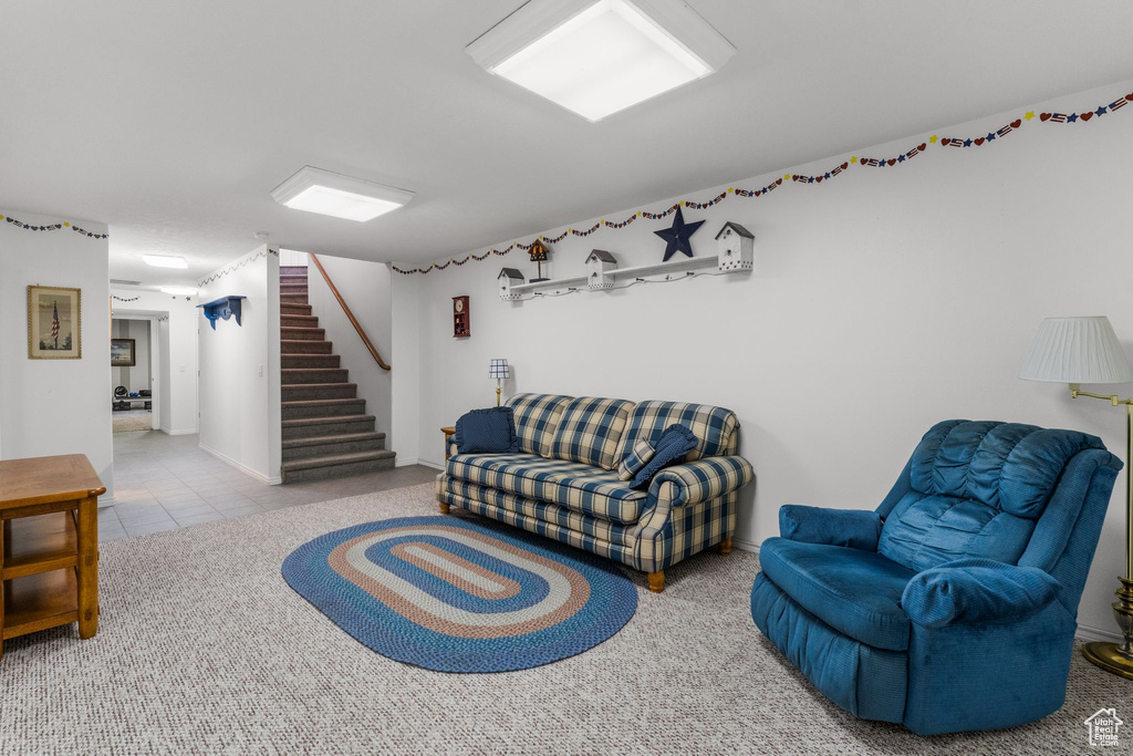 Tiled living area featuring stairway and baseboards