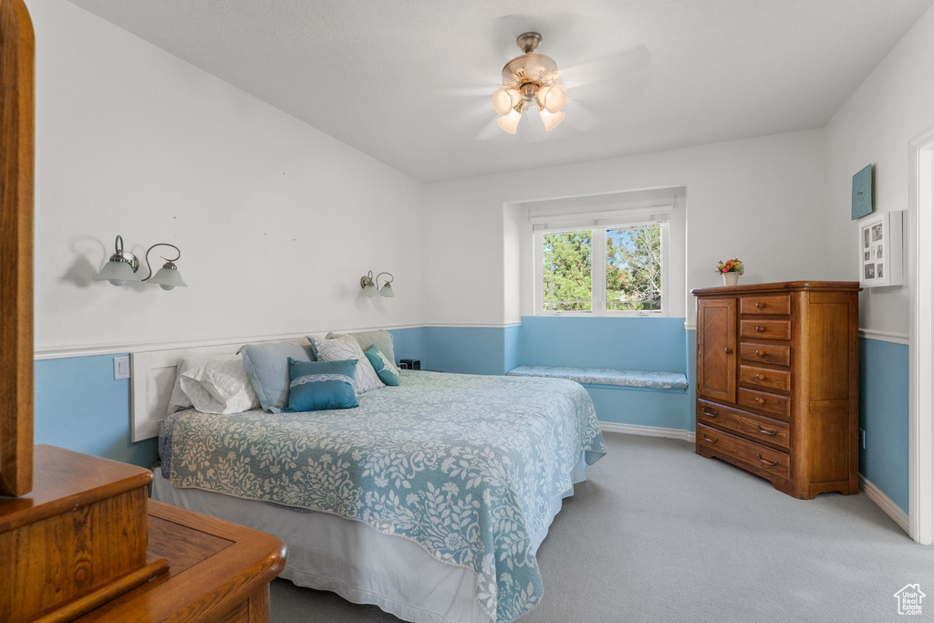 Bedroom with ceiling fan, light carpet, and baseboards