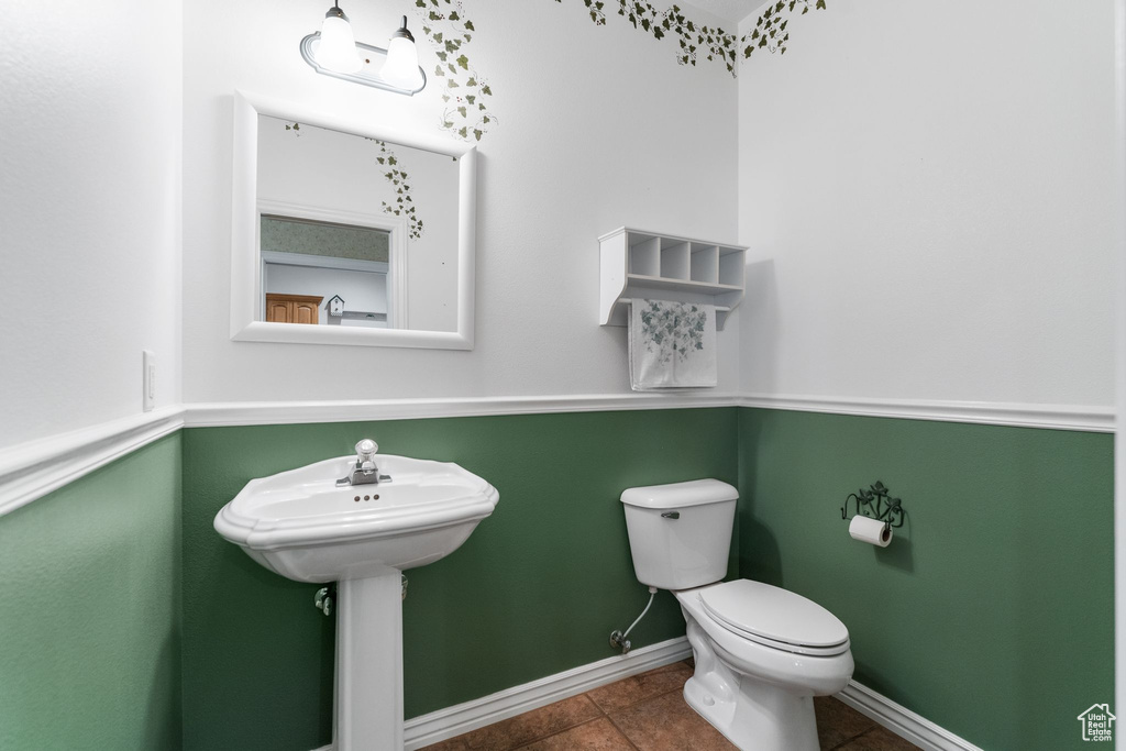 Half bathroom featuring toilet and baseboards
