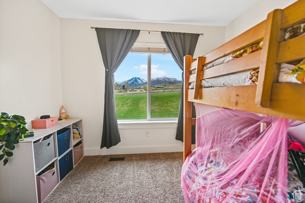 Bedroom with multiple windows, carpet flooring, a mountain view, and visible vents