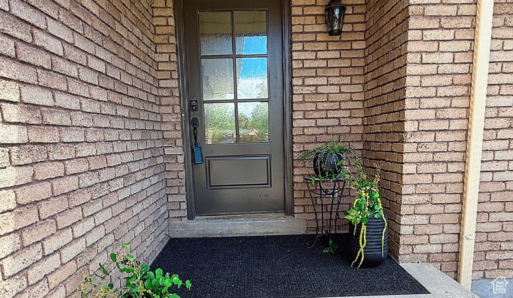 View of exterior entry featuring brick siding