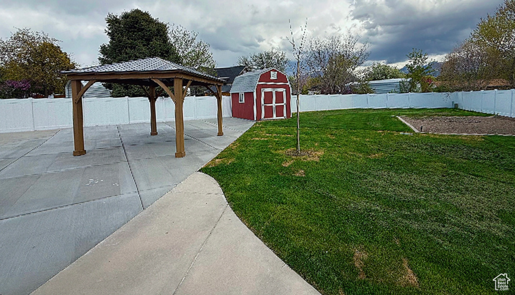 View of yard featuring a gazebo, a patio area, a fenced backyard, and a storage shed