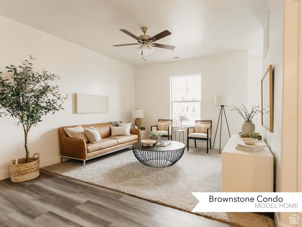 Living area featuring visible vents, baseboards, wood finished floors, and ceiling fan