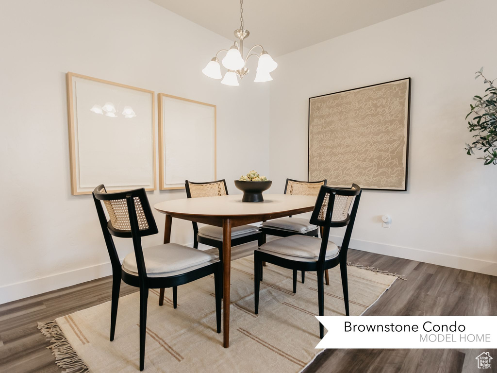 Dining space featuring baseboards, wood finished floors, and a notable chandelier