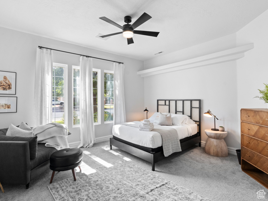 Carpeted bedroom with visible vents, a ceiling fan, and baseboards