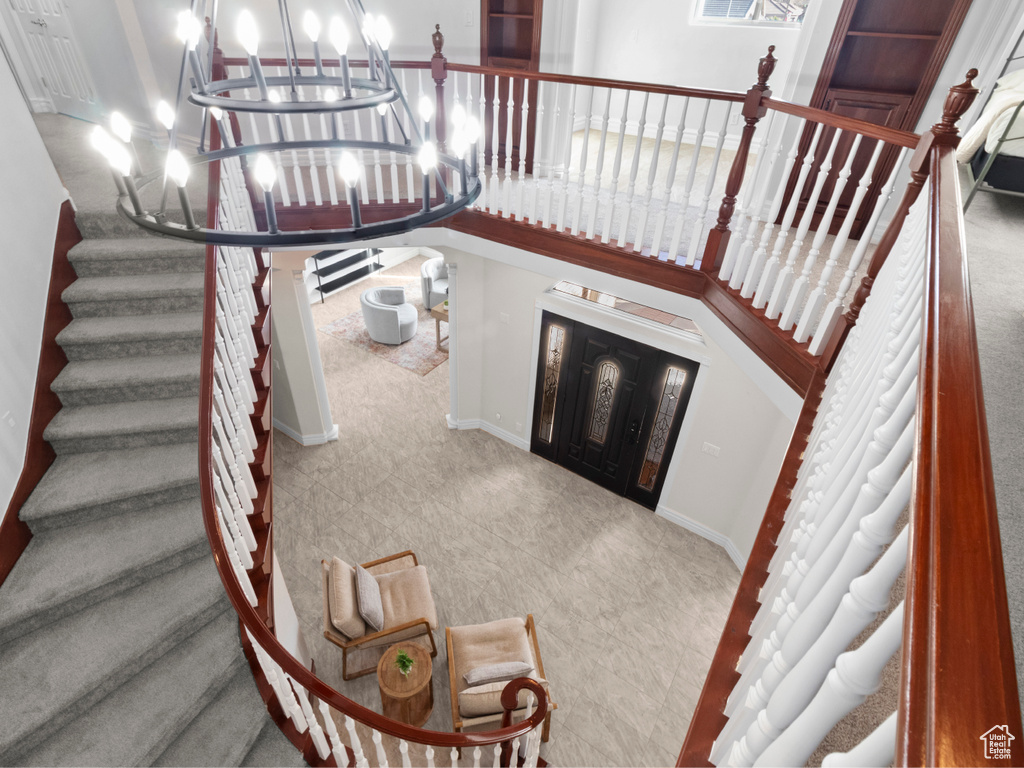 Staircase featuring arched walkways, a notable chandelier, and baseboards